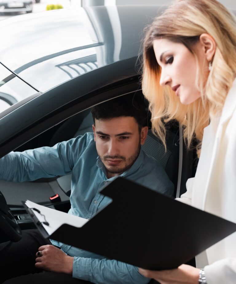 Car saleswoman shows documents for male client