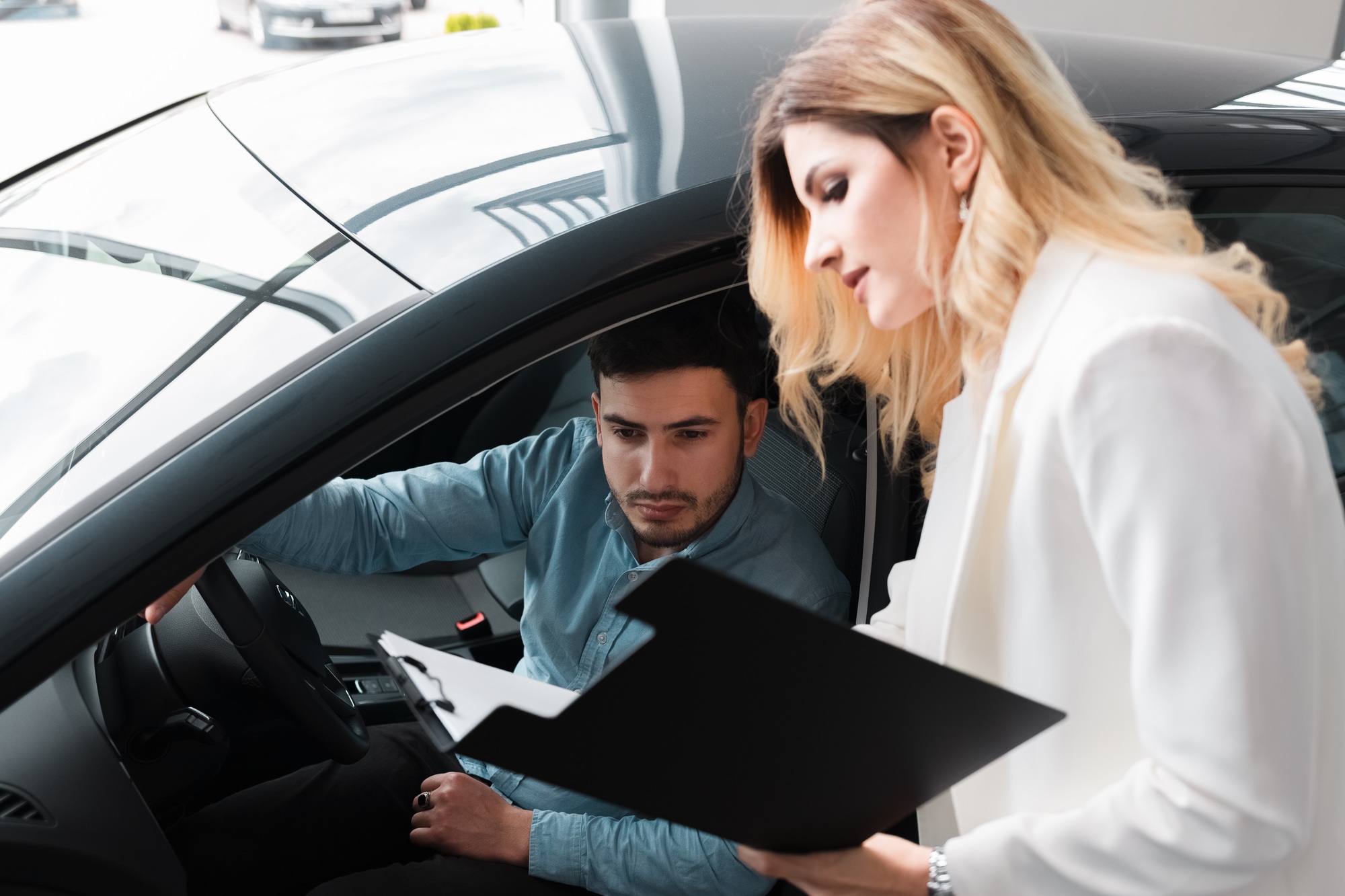 Car saleswoman shows documents for male client